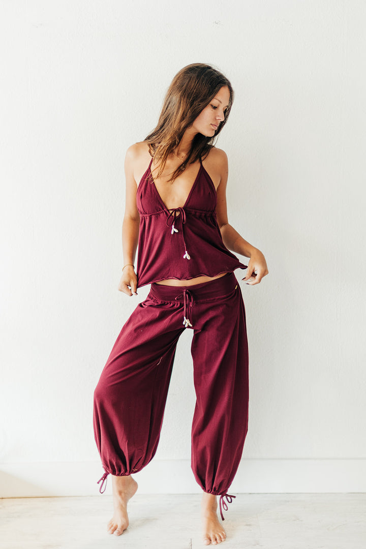 Woman wearing a burgundy pajama set on a white background