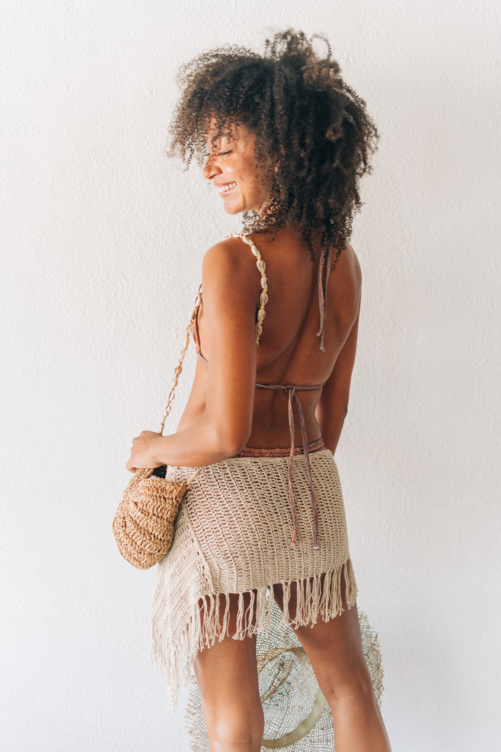 Woman wearing a crochet bikini with a white background
