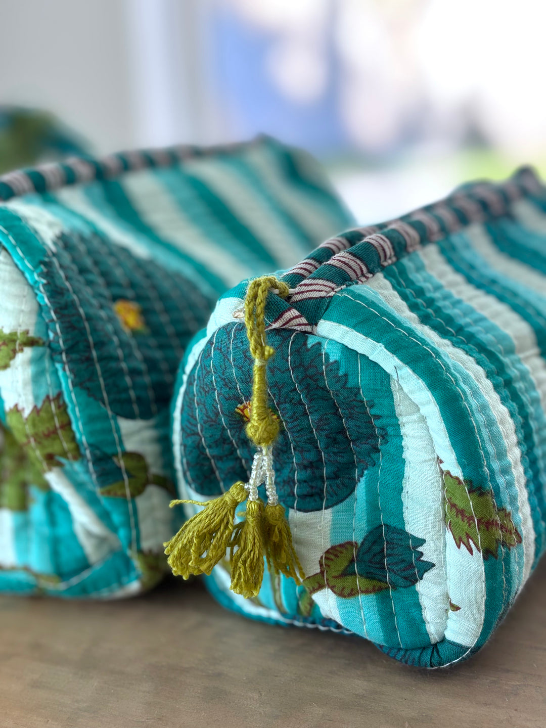 Two fabric pouches with colorful patterns on a wooden surface