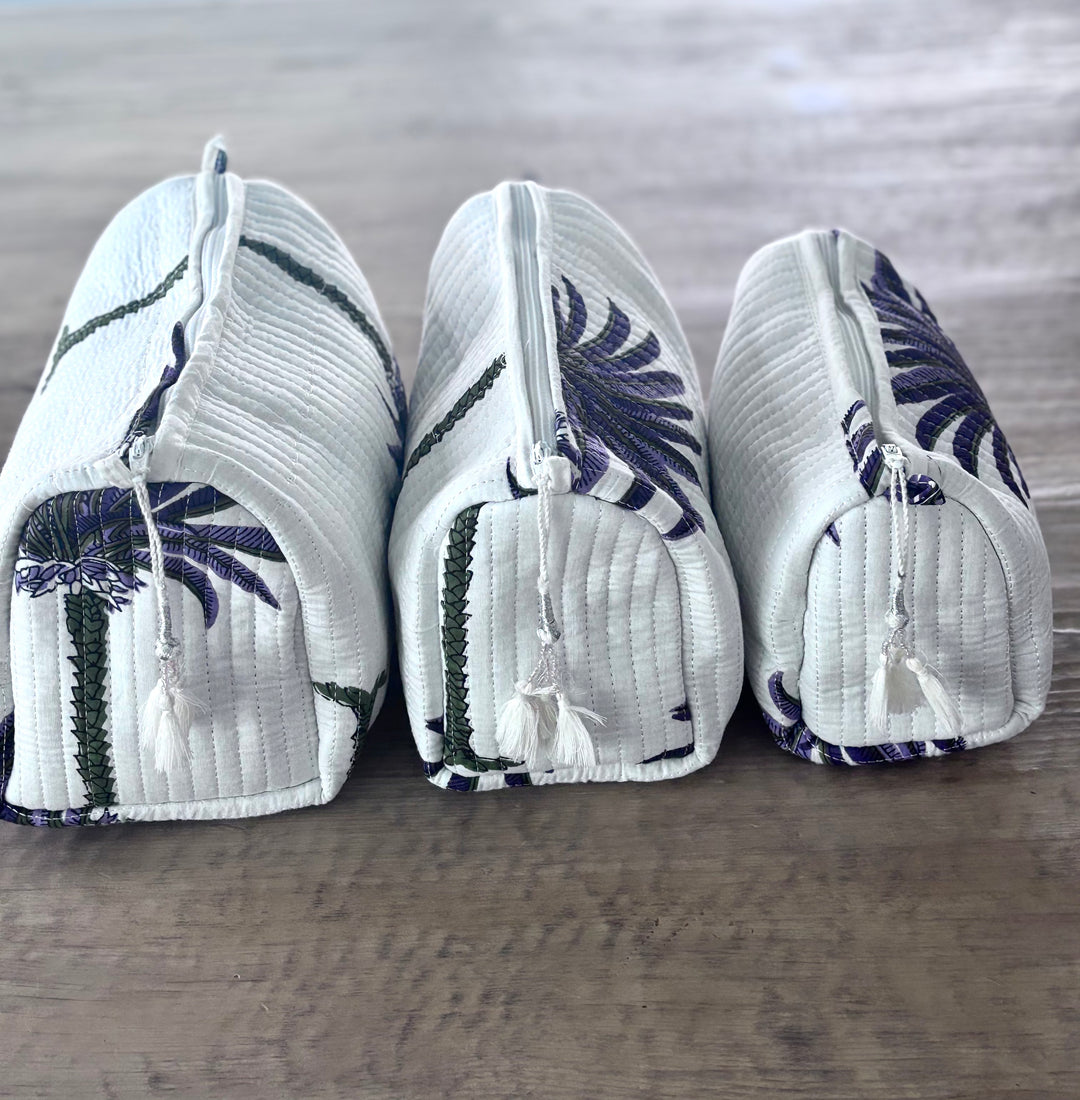 Three white pouches with blue floral patterns on a wooden surface