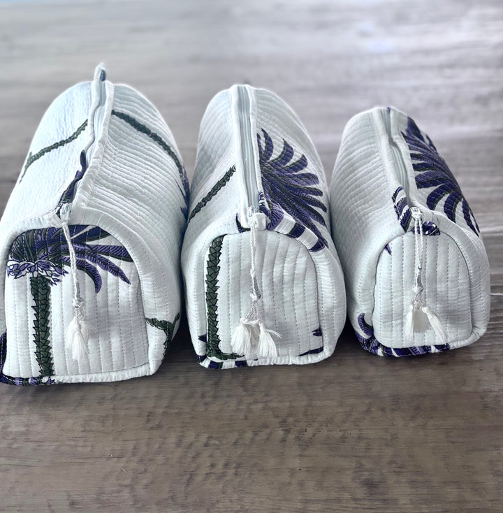 Three white pouches with blue floral patterns on a wooden surface