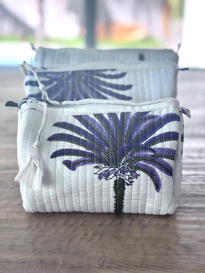 White pouch with blue palm tree design on a wooden surface