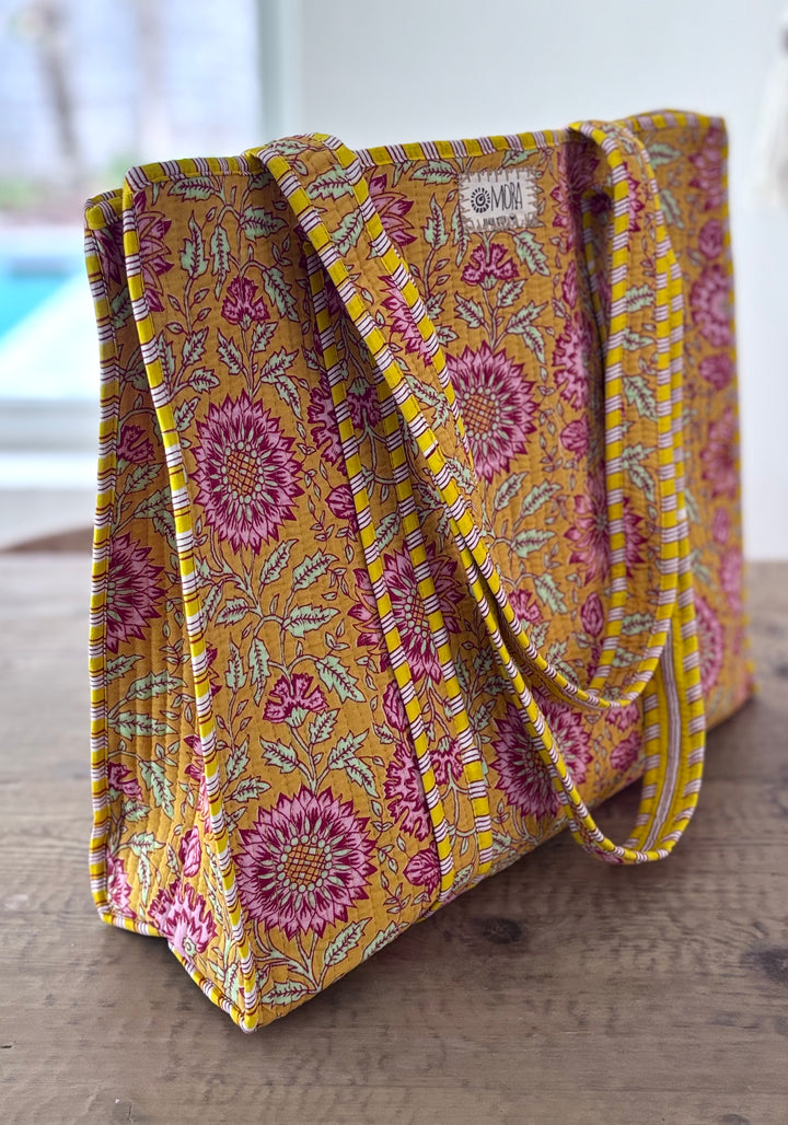 Yellow floral patterned bag on a wooden surface
