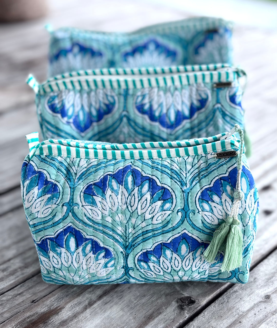 Two blue and green patterned fabric bags on a wooden surface