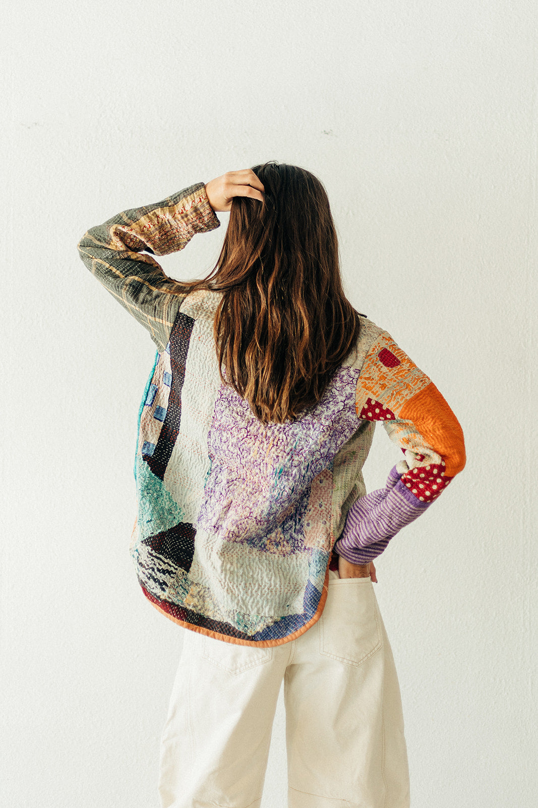 Person wearing a colorful, patterned sweater with a white background