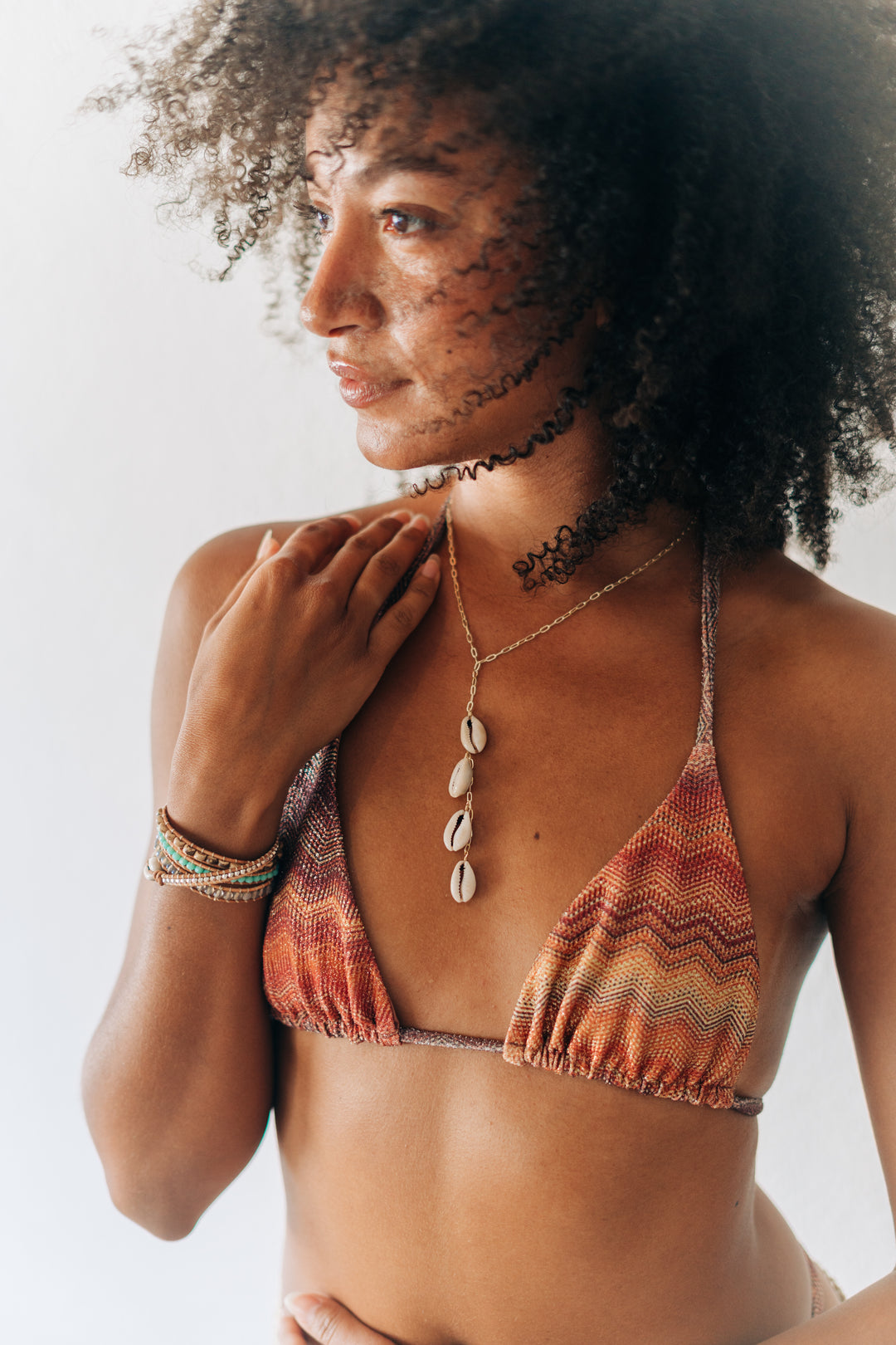 Woman wearing a patterned bikini top with a neutral background