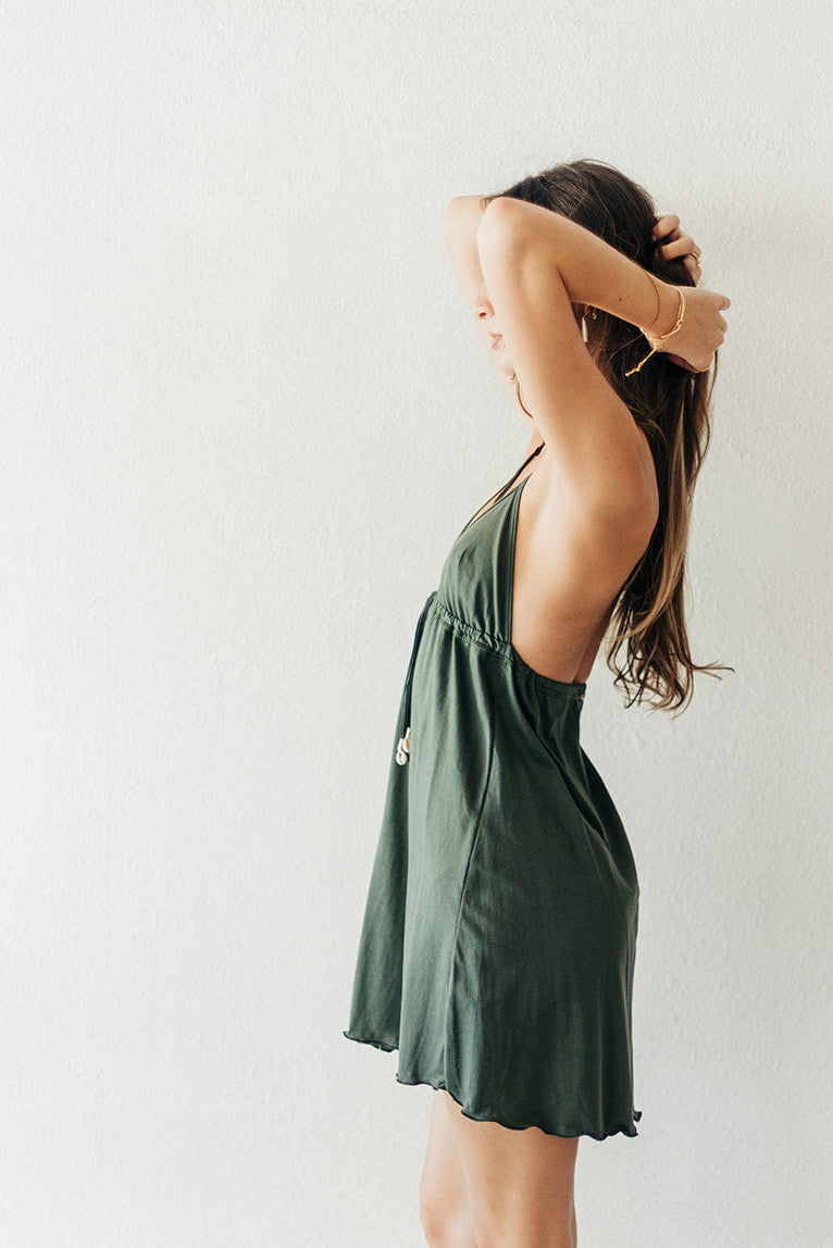 Woman wearing a green dress and brown boots against a white background