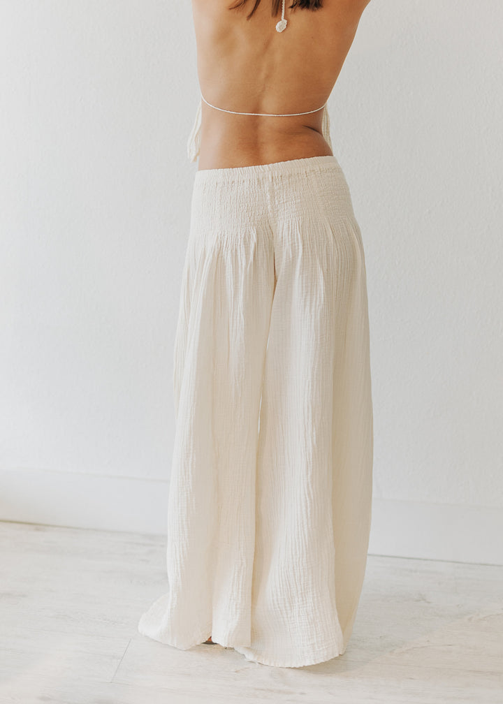 Person wearing light-colored wide-leg pants on a plain background