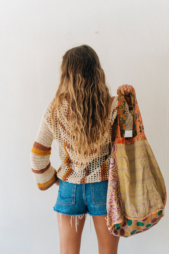 Person holding a colorful bag against a white background