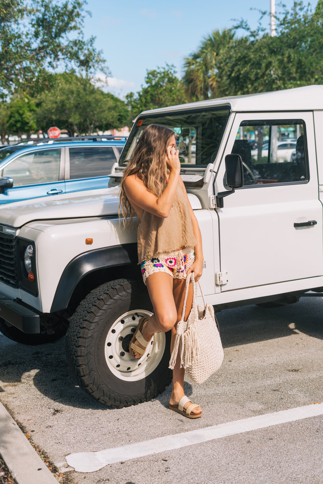 Woman standing next to a white SUV in a parking lot