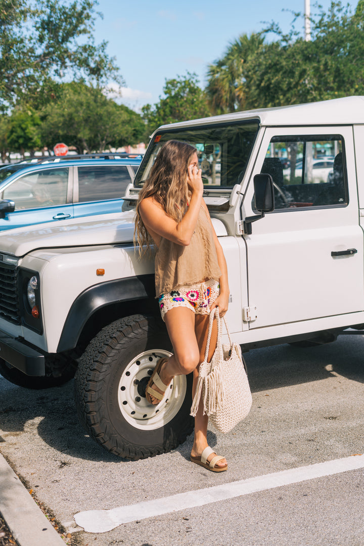 Woman standing next to a white SUV in a parking lot