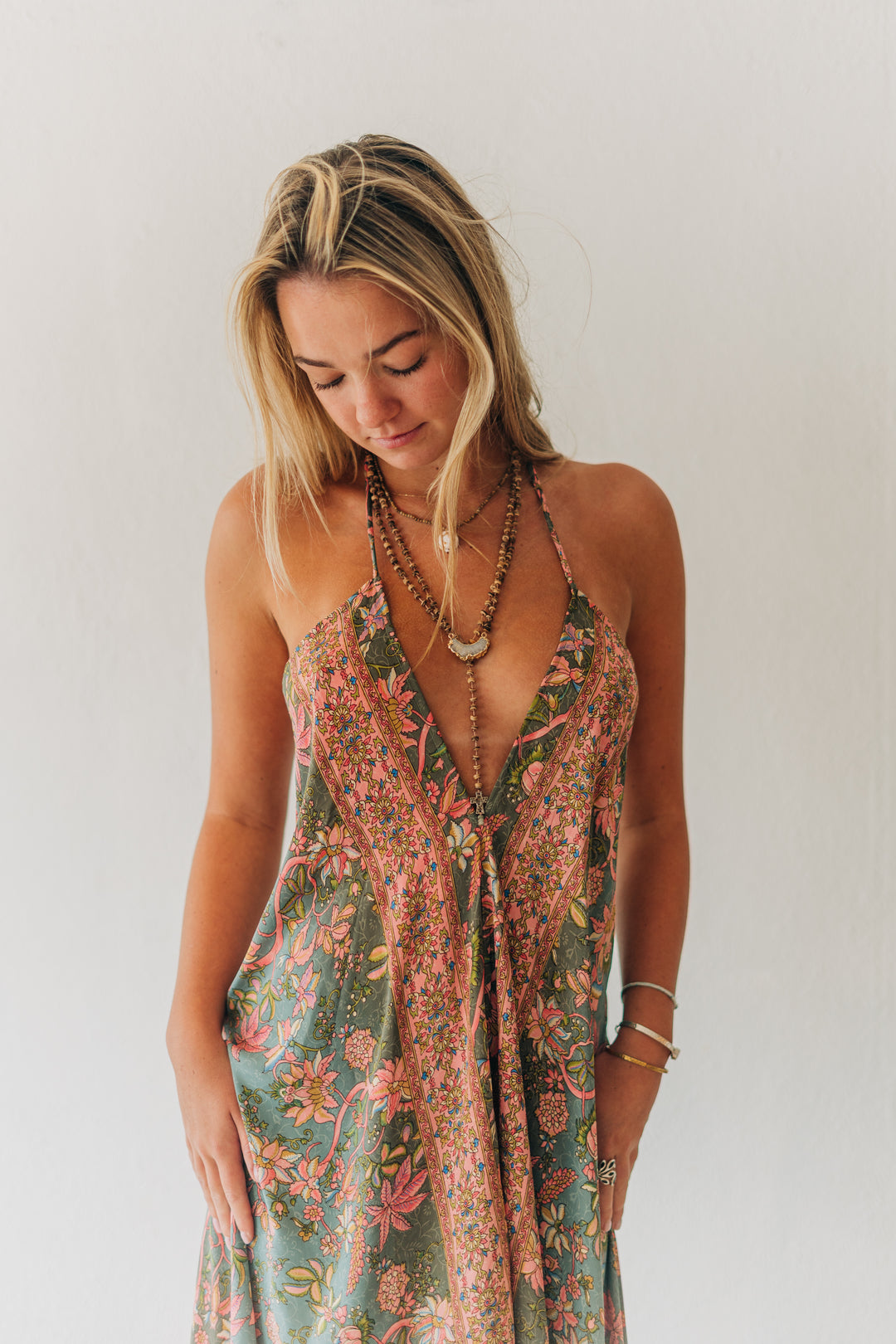 Woman wearing a floral dress against a plain background