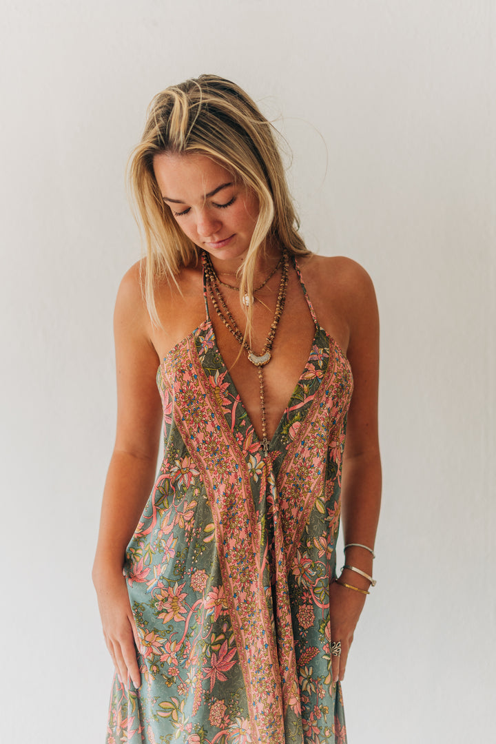 Woman wearing a floral dress against a plain background