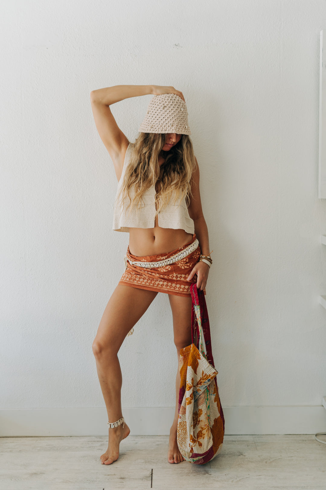 Woman holding a colorful bag against a white wall