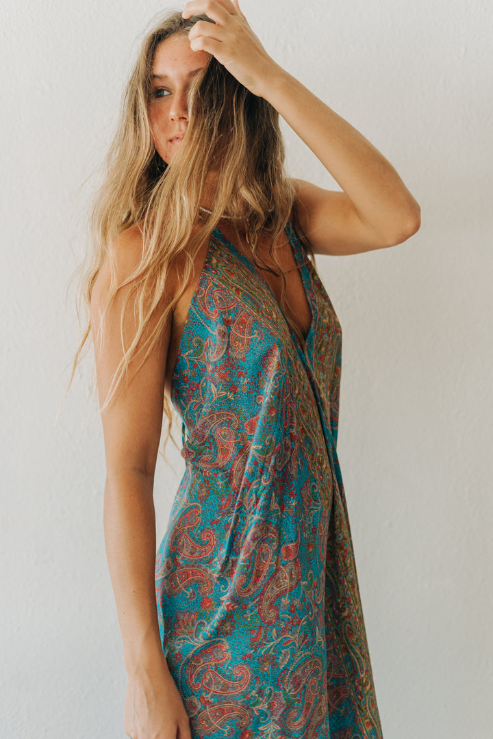 Woman wearing a patterned dress against a plain background