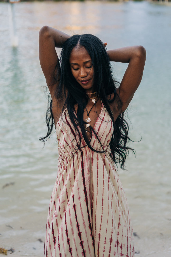 Woman in a tie-dye dress standing by water