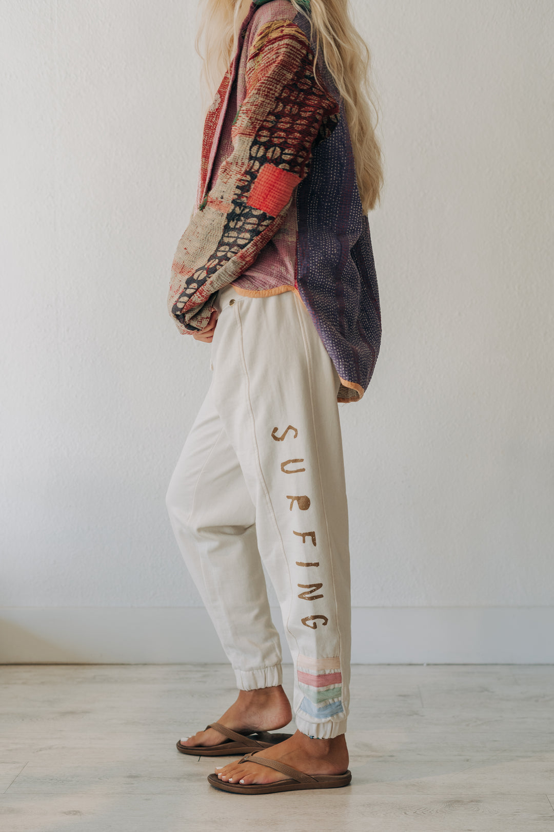 A person wearing cream-colored jogger pants with &