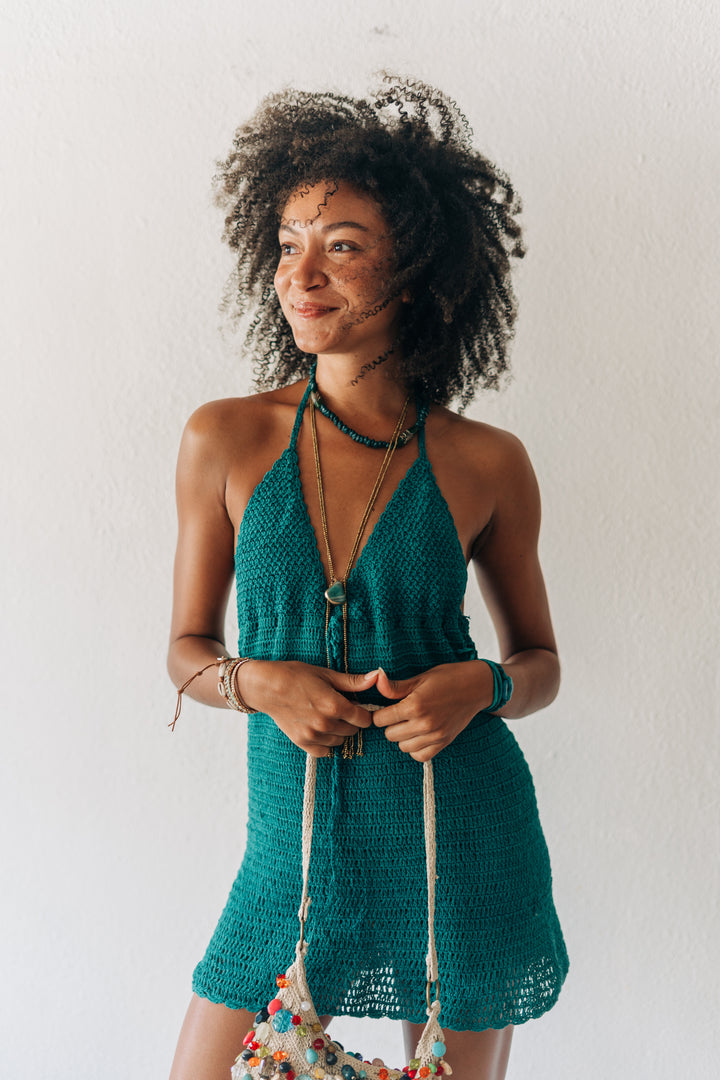 Woman wearing a green crochet dress against a white background
